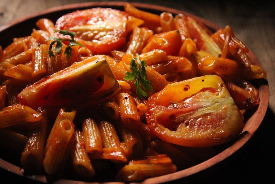 Savor a mouthwatering plate of penne pasta with juicy tomatoes, perfectly cooked.