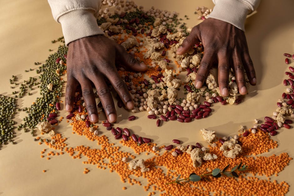 Top view of hands mixing colorful grains and vegan ingredients on a table.
