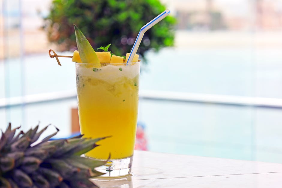Delight in a refreshing pineapple cocktail on a sunny day by the sea, perfect for a tropical escape.
