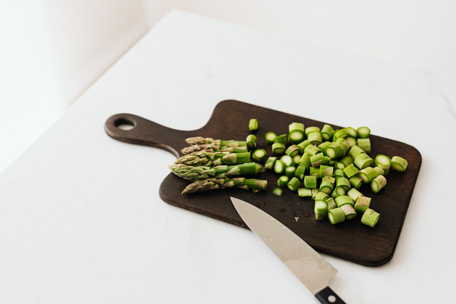 Chopped asparagus on a cutting board with knife