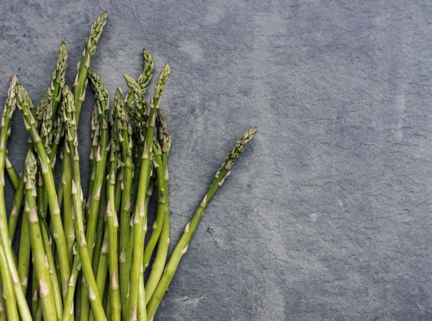 Fresh asparagus stalks on a slate surface