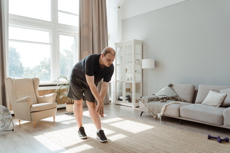 Man performing a stretching exercise in a sunlit living room, embracing a healthy lifestyle.
