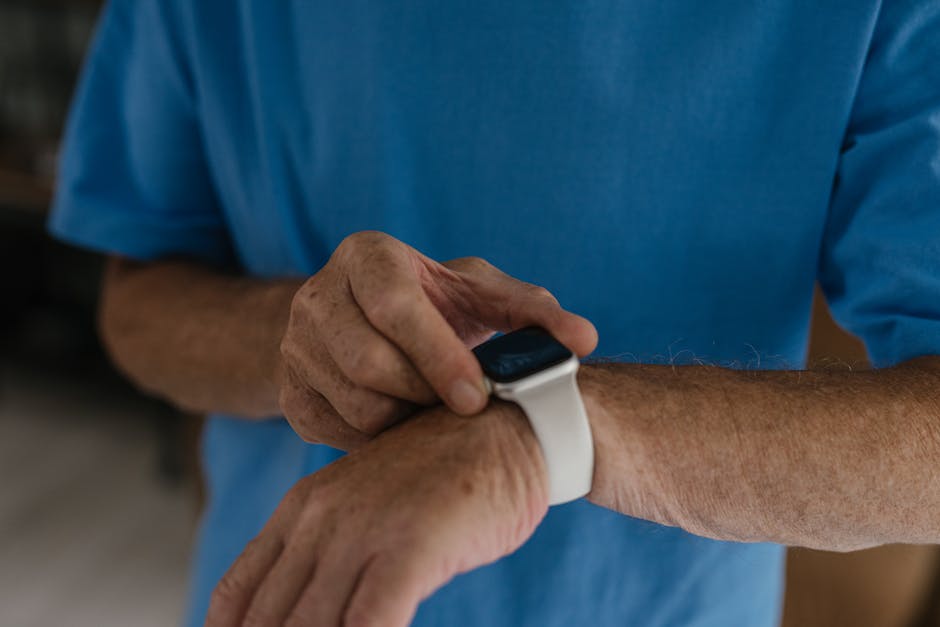 Close-up of a man's hands interacting with a smartwatch on his wrist.