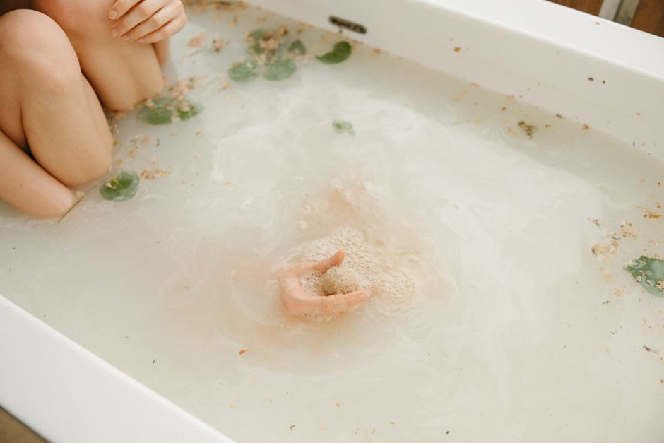 Relaxing bath scene with a natural bath bomb and gentle skin care, promoting wellness and calm.