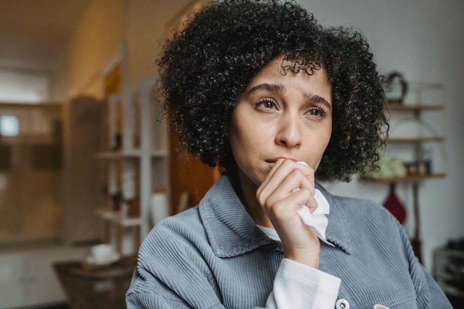 Woman holding a tissue feeling seasonal allergy symptoms